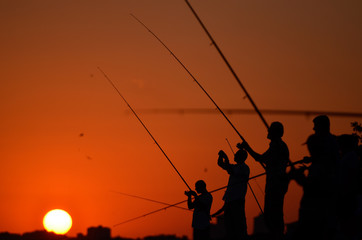 Fototapeta na wymiar Fisherman on a shore at sunset
