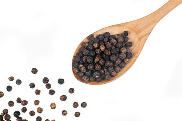 Close up heap of black pepper in wooden spoon, peppercorns isolated on white background, dried...