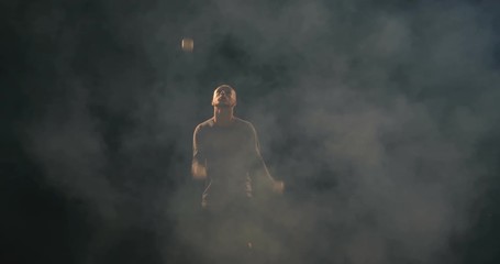 Juggler on the stage makes tricks with 7 ball.