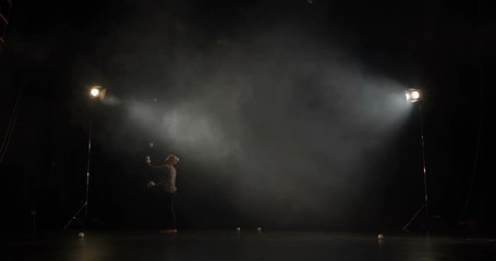 Amazing Juggler on the stage makes tricks with 7 ball.
