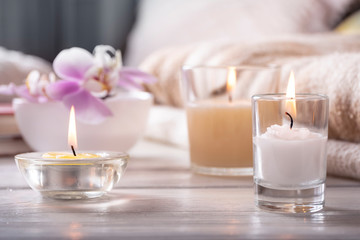 Home interior. Still life with detailes. Flower is vase, candles, on white wooden table, the concept of coziness. Selective focus.