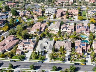 Aerial view suburban neighborhood with identical wealthy villas next to each other. San Diego, California, USA. Aerial view of residential modern subdivision luxury house with swimming pool.