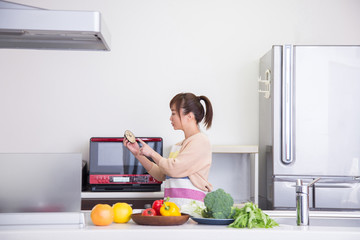 レンジで時短料理する女性