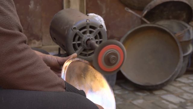 Forming a traditional cooper dish with an emery on the craftsman market. Fes, Morocco, North Africa