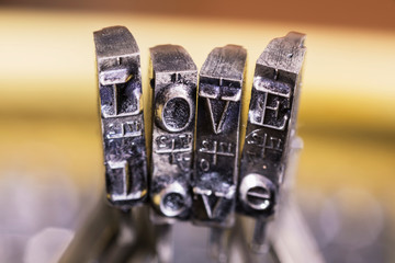 Macrophotography of typewriter hammers with LOVE word.