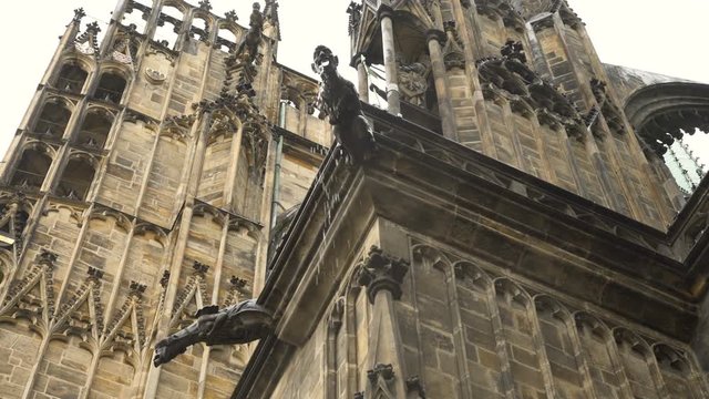 a Gargoyle  statues on building designed to convey water from a roof and away from the side of a building. human face. PragueSt. Vitus Cathedral