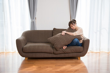 Obraz premium ソファに座って思い悩む女性