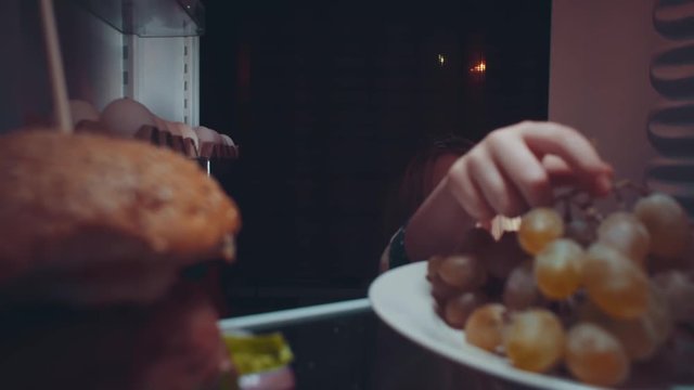Little cute baby takes food out of the refrigerator at night, the problem of choosing between healthy and unhealthy food.Irregular nutrition and sleep disturbance.