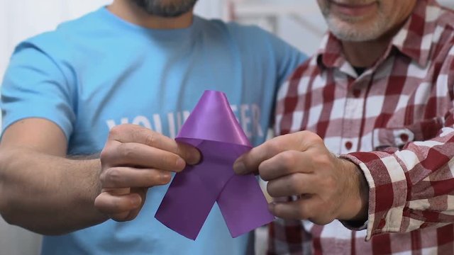 Volunteer visiting and supporting mature man suffering from Alzheimers disease