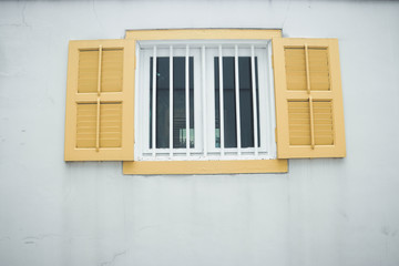 Yellow vintage window opens for ventilation.