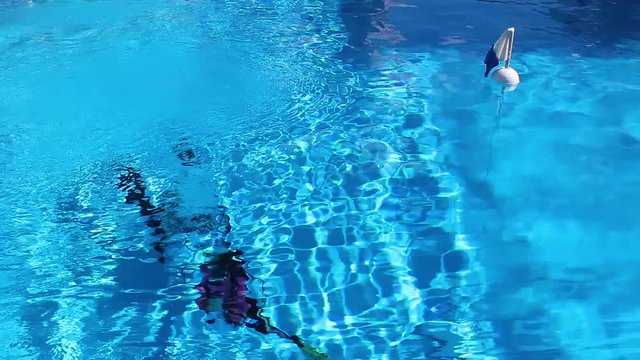 Scuba divers in a pool with a dive flag floating on top