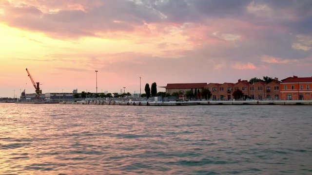 The Venice Ferry Terminal at sunset from a moving boat, Venice, Italy. Stabilized shot that pans to reveal more of the sunset.