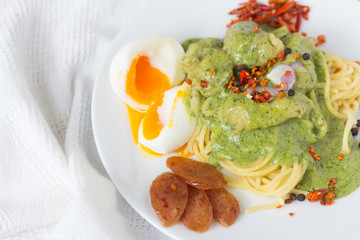 Spaghetti with fish and pesto sauce on white plate . Traditional italian cuisine.