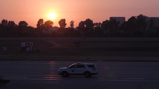 Airport security driving by in the sunset.