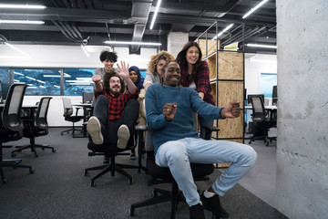 Fototapeta na wymiar multiethnics business team racing on office chairs