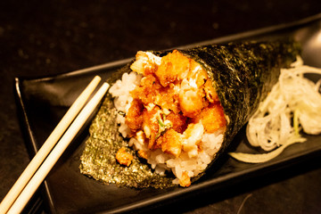 Fototapeta na wymiar Shrimp temaki sushi on black plate on wood background.