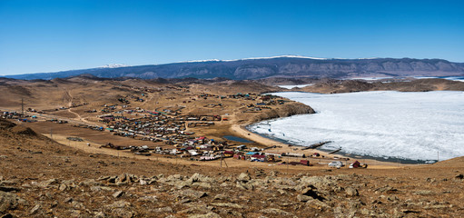 View of spring landscape in Siberia with part of frozen lake Baikal in the distance from the top view.