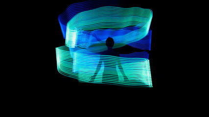 Human silhouette inside blue and green backlight. Biofield of man. Light painting photography. Long exposure.
