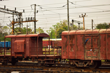 a rusty coloured Indian goods train guards compartment tied with goods train.