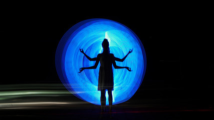 Shiva silhouette against blue backlight. Biofield of man. Light painting photography. Long exposure.