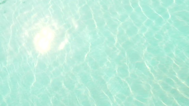locked isometric perspective of full frame turquoise water caustic ripples with clean sea floor and bright sun reflection
