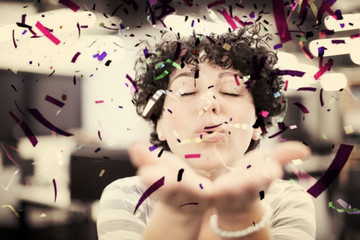 female software developer blowing confetti