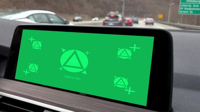 A green screen GPS on the dashboard of a modern luxury car. Corner markers for advanced screen replacement.  	