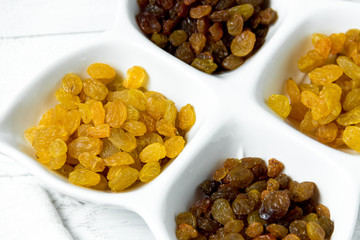 golden and brown raisins on plate. Top view of dried grapes.