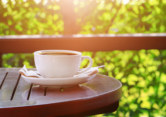 black coffee in cup white on table wood floor background in morning