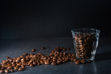 Coffee beans in glass on dark background with copy space