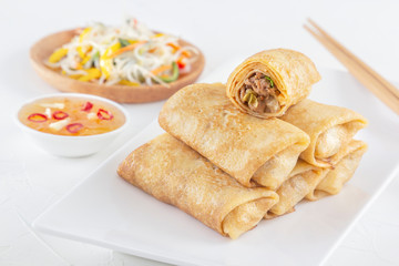 Traditional Chinese tortillas filled - bings in a plate on a white background, salads, Dam Sam snacks. Close-up