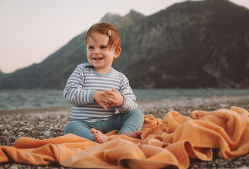 Cute little baby girl playing on a beach in summer day. Family Travel and vacation concept