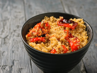 Boiled quinoa with baked bell pepper on the table. Vegetarian dish.