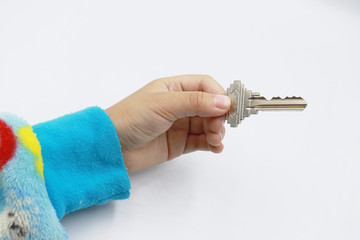 a key in kid hand on white background.