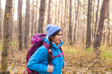 People and nature concept - Portrait of woman with backpack hiking in the forest