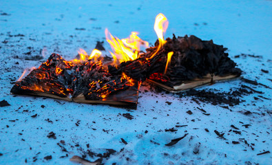 burning book in  snow. pages with the text in  open book burn with  bright flame.