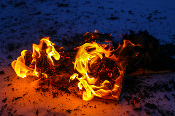 burning book in  snow. pages with the text in  open book burn with  bright flame.