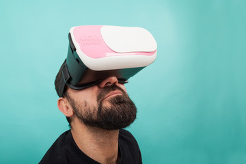Bearded man use virtual reality glasses, goggles. Guy in VR headset is looking at interactive screen. Playing mobile game app on device.