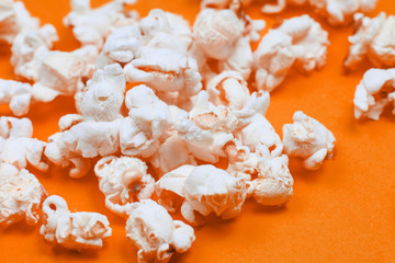 Closeup of popcorn grains on orange background