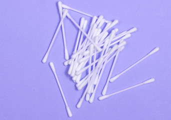 Ear hygiene cotton stick on purple background.