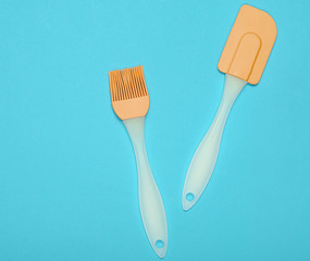Kitchen pastry silicone set (spatula and brush) on blue background. Top view, minimalism. Copy space.