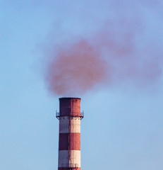 Smoke from pipes at the factory against the sky