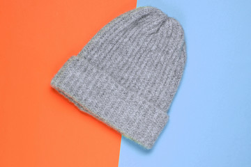 Winter woolen hat on a colored paper background, minimalism, top view.