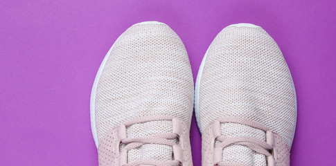 Sneakers. Sports shoes on purple paper background. Overhead shot of running shoes.Top view