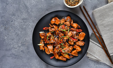 spicy chicken in sweet and sour sauce with chili pepper. teriyaki chicken's  with  sesame seeds. Chinese cuisine, Thai cuisine. Japanese food, copy space, recipe background, food flat lay