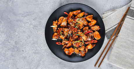 spicy chicken in sweet and sour sauce with chili pepper. teriyaki chicken's  with  sesame seeds. Chinese cuisine, Thai cuisine. Japanese food, copy space, recipe background, food flat lay