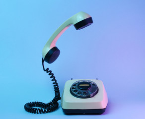 Old style rotary telephone with soaring telephone handle, neon light, 80s
