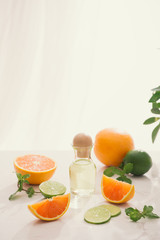 organic cosmetics with herbal extracts of lemon, orange, mint on bright background