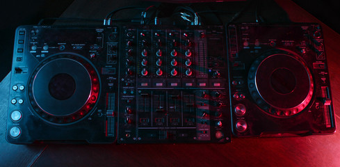 Fototapeta premium Night club, nightlife concept. Disco. DJ remote. Neon light. Top view