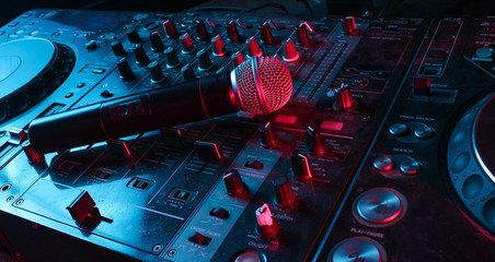 Night club, nightlife concept. Disco. Microphone on DJ remote. Neon red blue light - obrazy, fototapety, plakaty